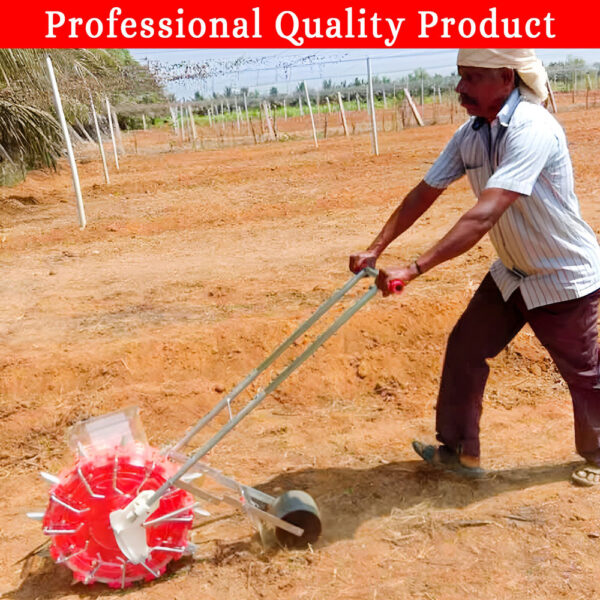 A person pushing a small, red manual seed planter with a transparent seed hopper and a rotating wheel with spikes. The planter is being used on a lawn.